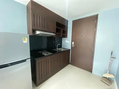 a kitchen with brown cabinets and a sink at Kris condo in Patong Beach