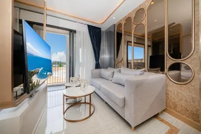 a living room with a couch and a large window at Apartments Bellevue Lagoon Phuket near Laguna in Phuket