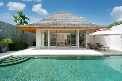 a house with a swimming pool and an umbrella at Anchan 4 bedroom near Beach in Phuket