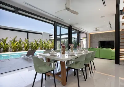 a dining room with a table and chairs and a pool at Sleek Designed Sunset Garden Villa 05 - 4 BR with Salt Private Pool 12M in Ban Saiyuan (1)