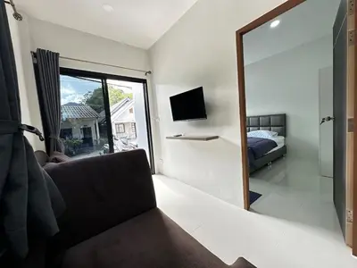 a bedroom with a mirror and a bed and a television at Layla house, Bang Tao beach in Ban Thalat Choeng Thale