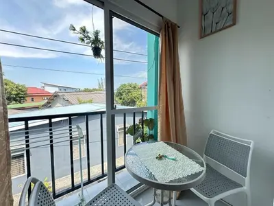 a balcony with a table and chairs and a window at MAM house in a quiet and stylish location in Ban Thalat Choeng Thale