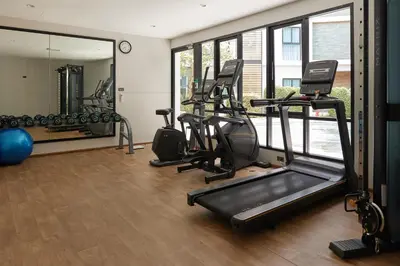 a gym with treadmills and ellipticals and a mirror at Cozy Apartment at Rawai with Pool Access in Phuket Town