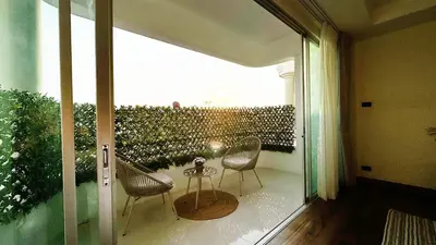 a patio with two chairs and a table on a balcony at Mali Villa 57 in Patong Beach
