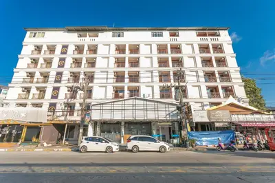 a white building with cars parked in front of it at sunflower \u4e00\u5367\u7cbe\u54c1\u5927\u5e8a\u623f\u5e26\u9633\u53f0 in Patong Beach