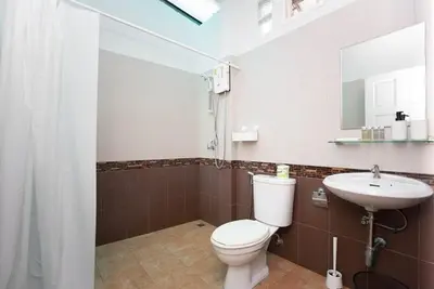 a bathroom with a toilet and a sink at NI houses in Ban Thalat Choeng Thale