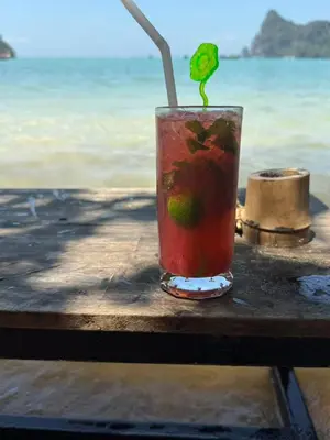 a drink sitting on a table next to the ocean at fruit paradise hotel in Patong Beach