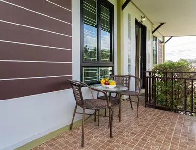 a patio with two chairs and a table on a porch at House in a quiet and stylish location NU8, Bang Tao in Surin Beach