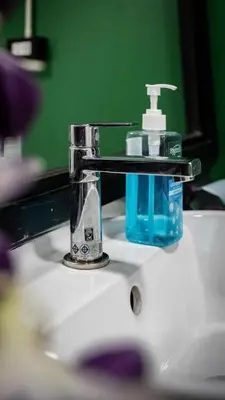 a bathroom sink with a bottle of soap on it at The highdogs hostel in Phi Phi Don