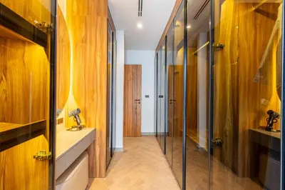 a bathroom with wooden walls and a glass shower door at The S Villas in Laguna Phuket
