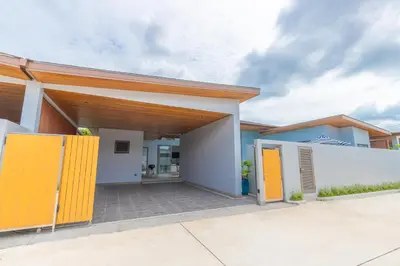 a house with yellow doors in a driveway at The S Villas in Laguna Phuket