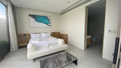 a bedroom with a white bed and a table at 4bdr New Pool Villa Bangtao by Capital Pro ASH-37 in Ban Pak Lak