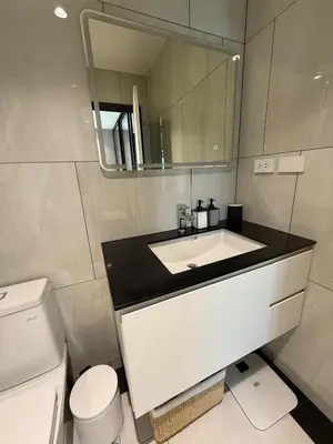 a bathroom with a sink and a toilet and a mirror at New and Stunning 1BR, The Title Legendary by UNO in Bang Tao Beach