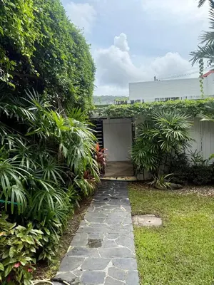 a garden with a stone path leading to a garage at Suriyasom Villa 5 in Thalang