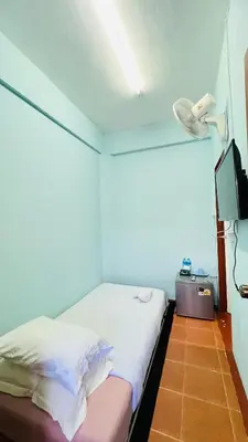a small room with a bed and a television at Daisy House Patong in Patong Beach
