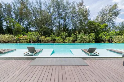a swimming pool with two lounge chairs next to it at Laya Resort 1 bedroom By Ere in Layan Beach