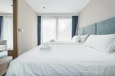 a bedroom with a large white bed with a large window at Laya Resort 1 bedroom By Ere in Layan Beach