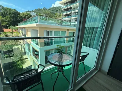 a balcony with a table and chairs on a balcony at The Bay cliff By Tris in Patong Beach