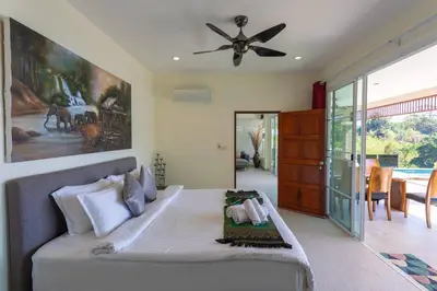 a bedroom with a bed and a ceiling fan at Luxury Seaview Villa, Infinity Pool, Sunset in Karon Beach