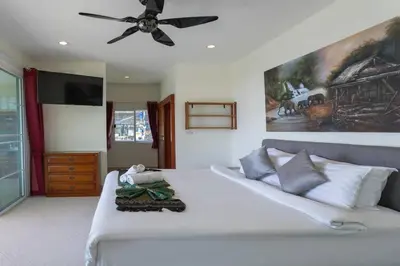a bedroom with a white bed with a ceiling fan at Luxury Seaview Villa, Infinity Pool, Sunset in Karon Beach