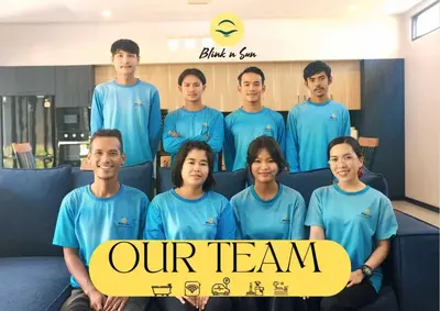 a group of men and women in blue shirts holding a sign at Tropical Dream Villa in Rawai Beach