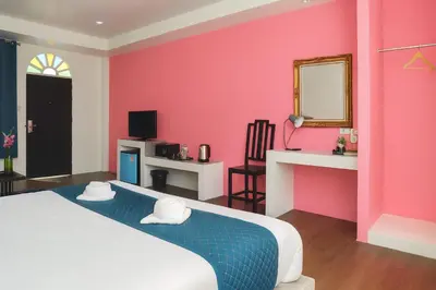 a bedroom with a bed and a pink wall at Chic Boutique Hotel, Patong in Patong Beach