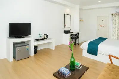 a hotel room with a bed and a table with a vase at Chic Boutique Hotel, Patong in Patong Beach