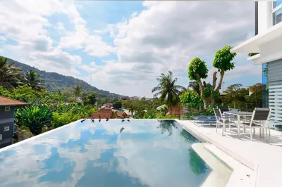 a swimming pool with a table and chairs on a house at Villa Beverly Private Infinity Pool with Seaview near Kata Beach in Kata Beach