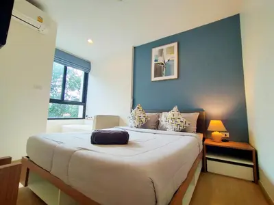 a bedroom with a large bed with a blue wall at Cozy room near beaches & restaurants in Bang Tao Beach