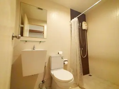 a bathroom with a white toilet and a shower at Cozy room near beaches & restaurants in Bang Tao Beach