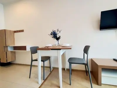 a table with chairs and a vase of flowers on it at Cozy room near beaches & restaurants in Bang Tao Beach