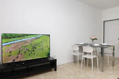a dining room with a tv and a table with chairs at Sisters Ari 2-bedrooms house, Bang Tao beach in Ban Thalat Choeng Thale
