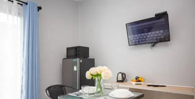a room with a table with a refrigerator and a tv at Siam Condo Apartment, 600 metters to Bang Tao beach in Surin Beach