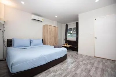 a bedroom with a large bed with blue pillows at SIRI apartments Bangtao beach in Ban Thalat Choeng Thale