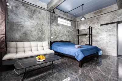 a bedroom with a bed and a table and a couch at Sam's Unique and Stylish houses, 10 min to the beach in Ban Thalat Choeng Thale