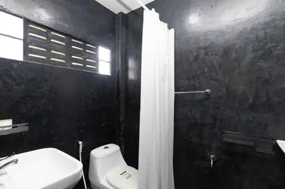 a bathroom with a white toilet and a sink at Sam's Unique and Stylish houses, 10 min to the beach in Ban Thalat Choeng Thale