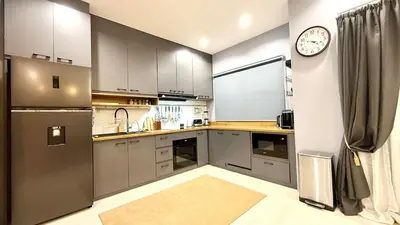 a kitchen with stainless steel appliances and a clock on the wall at Stylish Family Townhouse 3 Bdr in Chalong