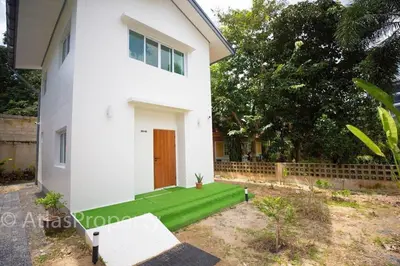 a house with a green lawn in front of it at Japanese houses in Phuket in Ban Thalat Choeng Thale