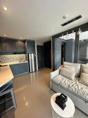 a living room with a couch and a kitchen at CityGate Kamala 1 bedroom By Ere L309 in Kamala Beach