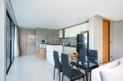 a kitchen and dining room with a glass table and chairs at Duplex Villa Natural Touch A2 2BR with scenic view and rooftop terrace in Kamala Beach
