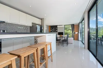 a kitchen with wooden tables and a dining room at Duplex Villa Natural Touch A2 2BR with scenic view and rooftop terrace in Kamala Beach