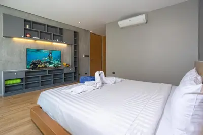 a bedroom with a white bed and a flat screen tv at Duplex Villa Natural Touch A2 2BR with scenic view and rooftop terrace in Kamala Beach