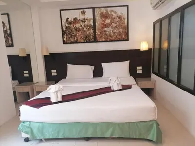 a bedroom with a large white bed with bows on it at AtWhitePatong in Patong Beach