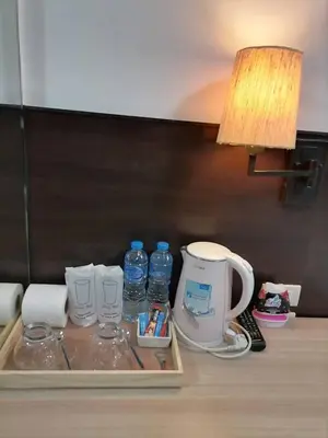 a table with bottles of water and a lamp on it at AtWhitePatong in Patong Beach