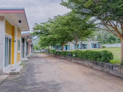 a dirt road between two houses with trees at Sunisa Resort in Phuket Town
