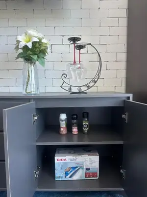 a shelf with a table and a vase with flowers at Grand Patong Apartment 7FL in Patong Beach