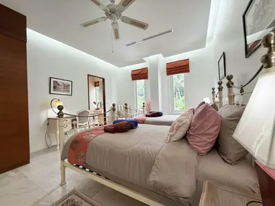 a bedroom with two beds and a table at Kamala Seaview - 3 BR Private Pool Villa in Kamala Beach