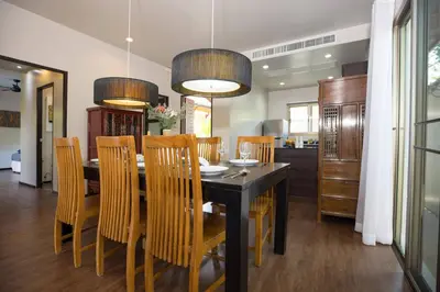 a dining room with a black table and chairs at Private 3BR Pool Villa Mylico 3min drive Nai Harn Beach in Rawai Beach