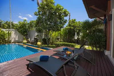 a deck with a table and chairs next to a swimming pool at Private 3BR Pool Villa Mylico 3min drive Nai Harn Beach in Rawai Beach