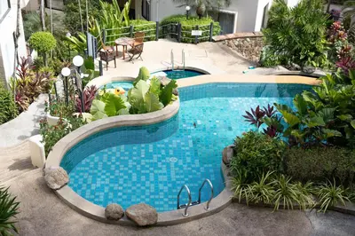 a swimming pool in a garden with plants at 3 BR Seaview Apt with pool access ADMC 100-2 in Ban Ao Makham